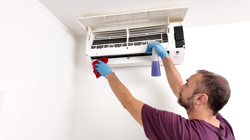 hombre limpiando aire acondicionado
