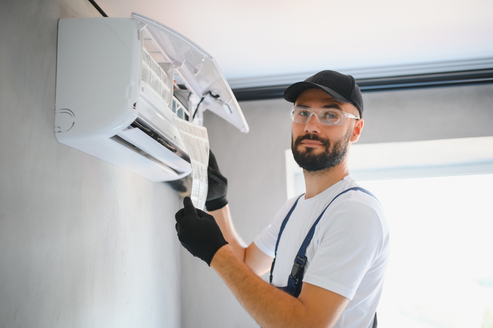 reparador de sistemas de aire acondicionado mirando a la camara